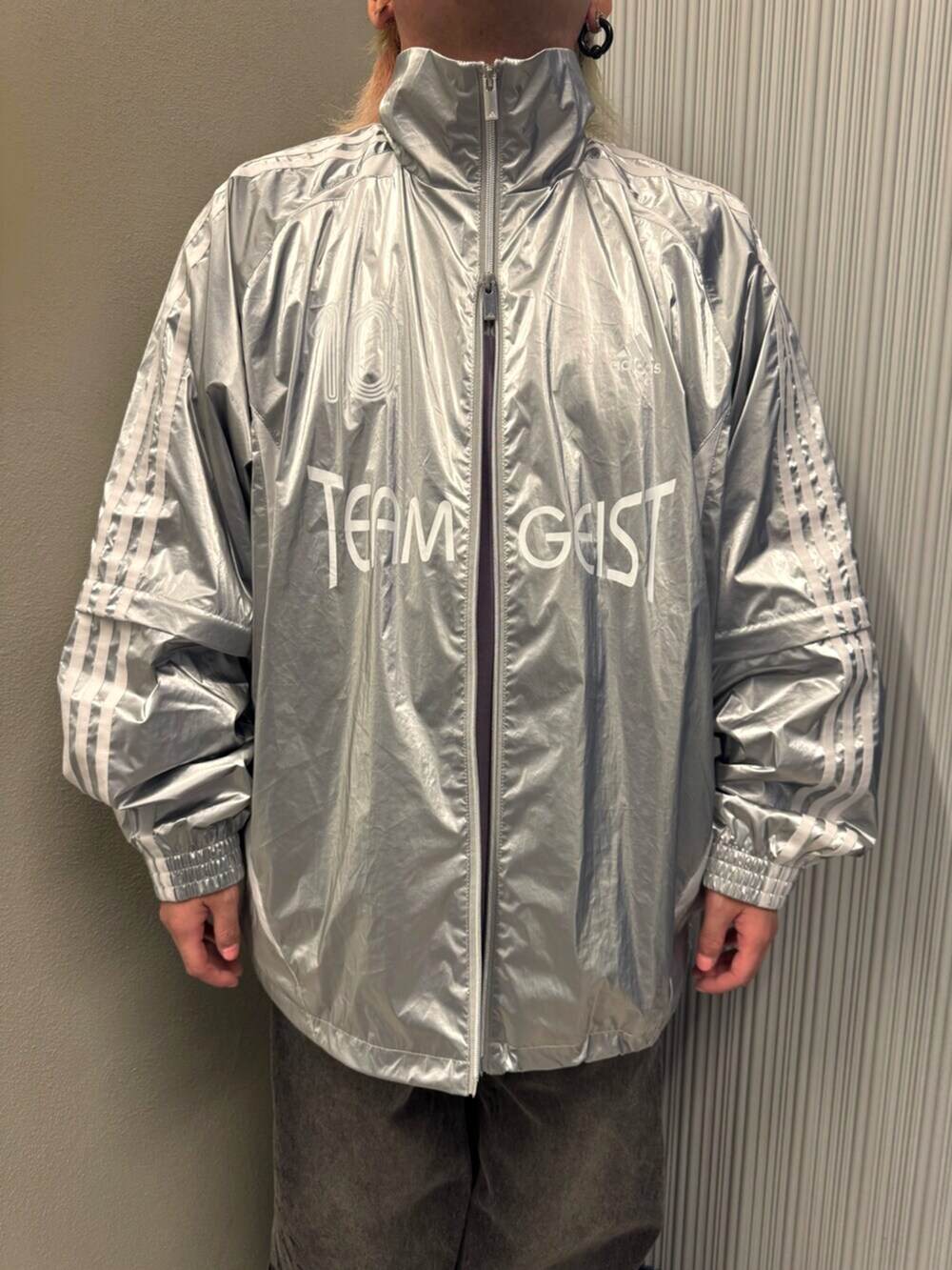 シルバー系のスニーカー、シルバー系のジャージ、パープル系のTシャツ/カットソーを着用したメンズの秋コーディネートの4枚目の写真