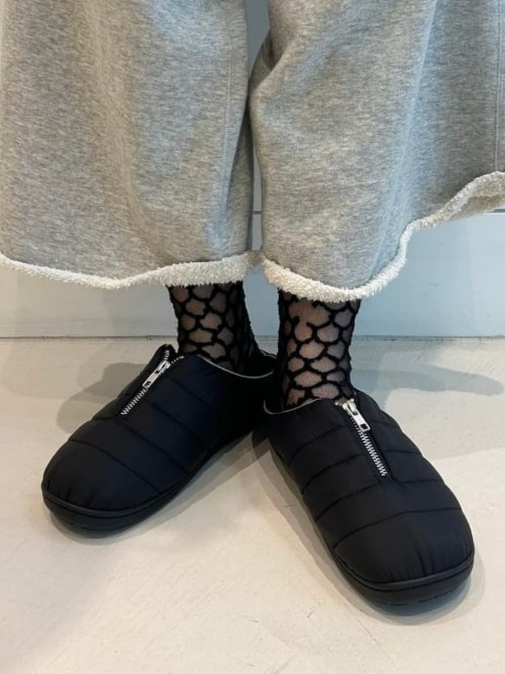 ブラック系のサンダルを着用したレディースの秋コーディネートの2枚目の写真