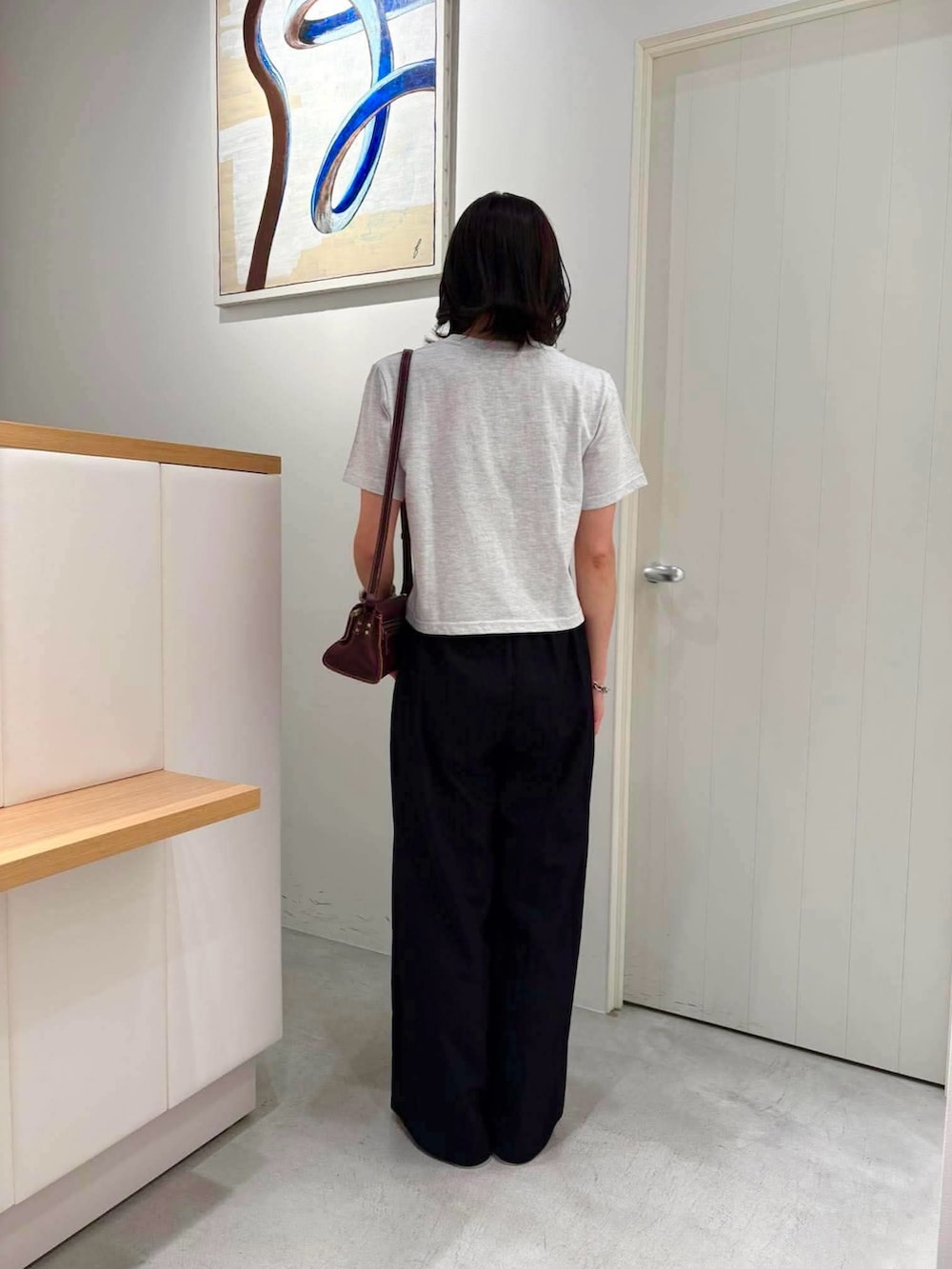 グレー系のTシャツ/カットソー、ブラウン系のショルダーバッグ、グリーン系のサンダルを着用したレディースの夏コーディネートの3枚目の写真