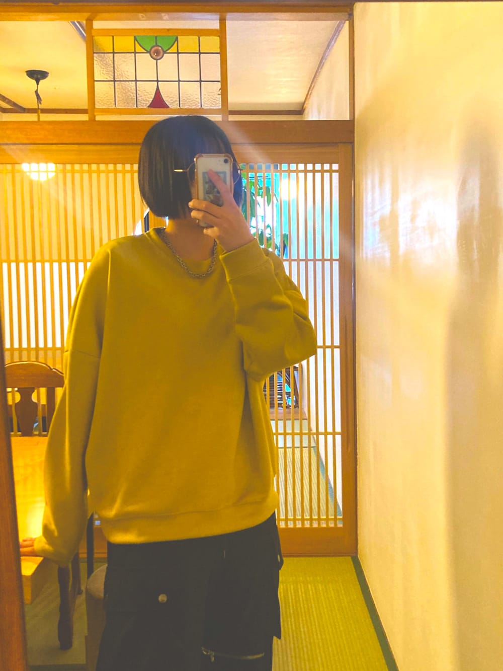 ブラック系のカーゴパンツ、イエロー系のスウェット、シルバー系のネックレスを着用したレディースの冬コーディネートの2枚目の写真