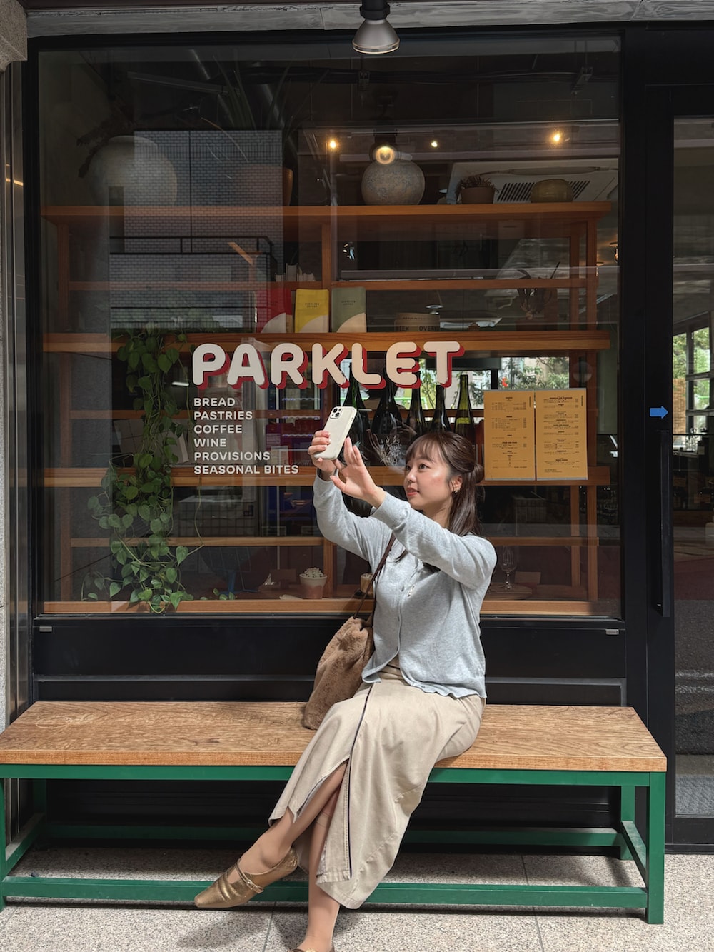 ベージュ系のスカート、ホワイト系のパンプス、グレー系のカーディガン/ボレロを着用したレディースの秋コーディネートの2枚目の写真