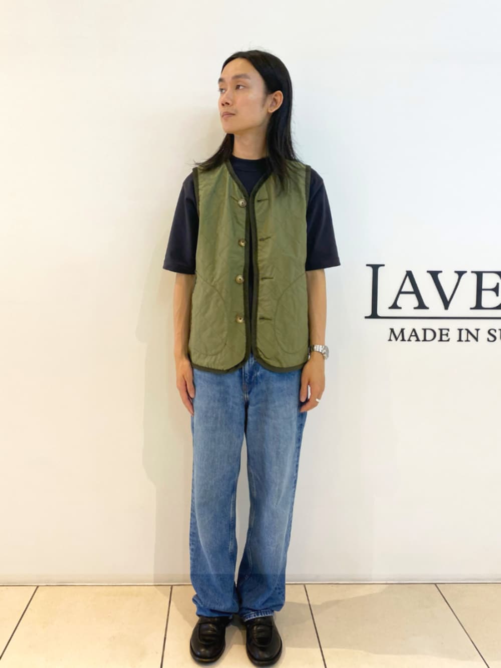 グリーン系のベストを着用したメンズの秋コーディネートの2枚目の写真