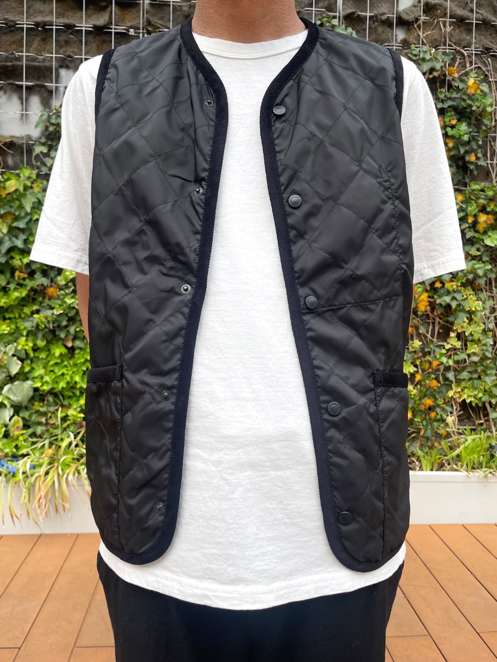 ブラック系のベスト、ホワイト系のTシャツ/カットソーを着用したメンズの春コーディネートの2枚目の写真