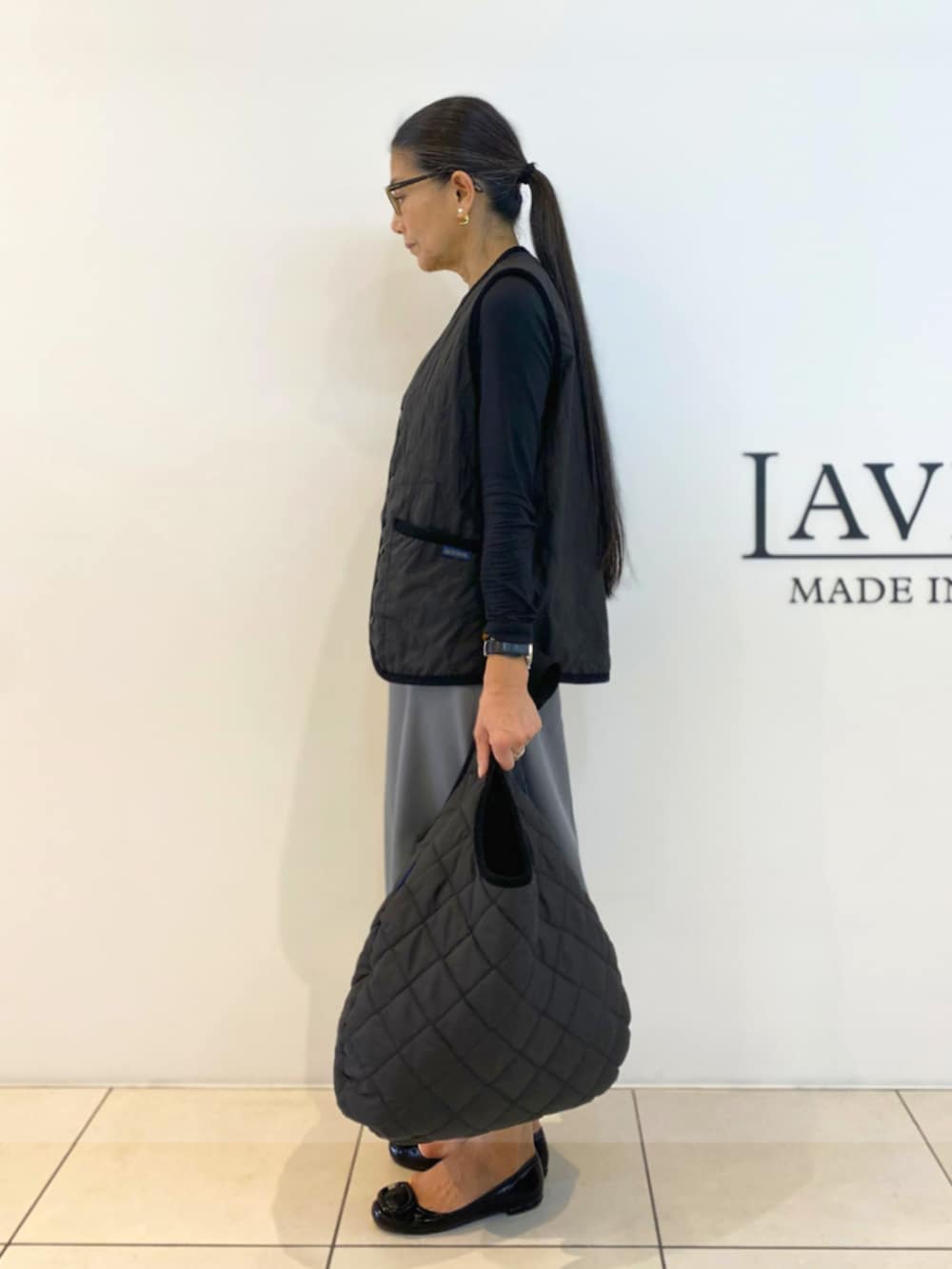 ブラック系のベスト、ブラック系のショルダーバッグを着用したレディースの秋コーディネートの2枚目の写真