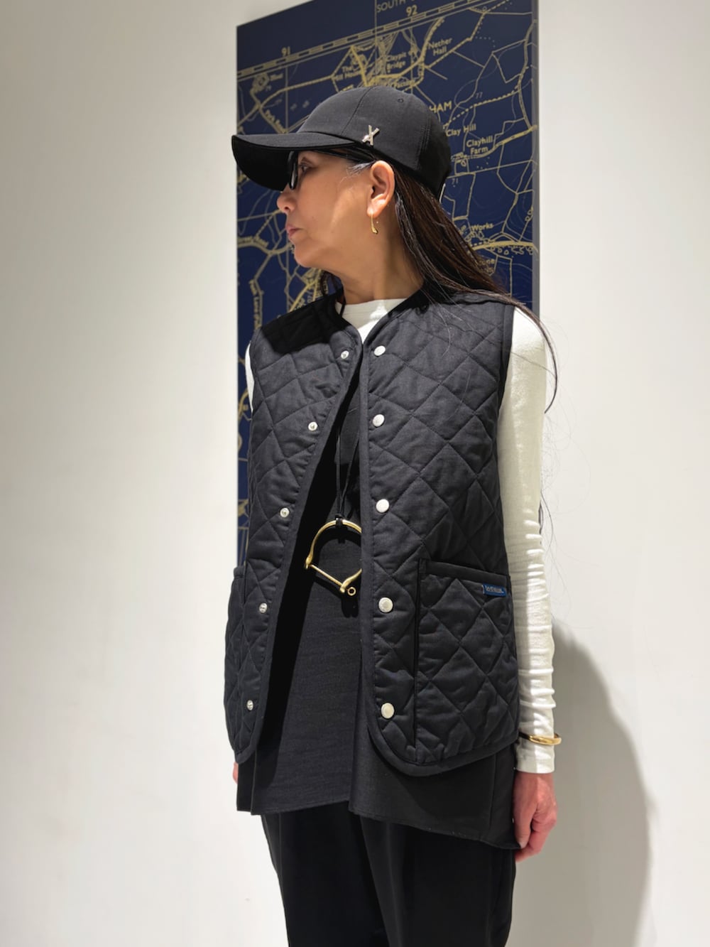 ブラック系のベストを着用したレディースの春コーディネートの2枚目の写真