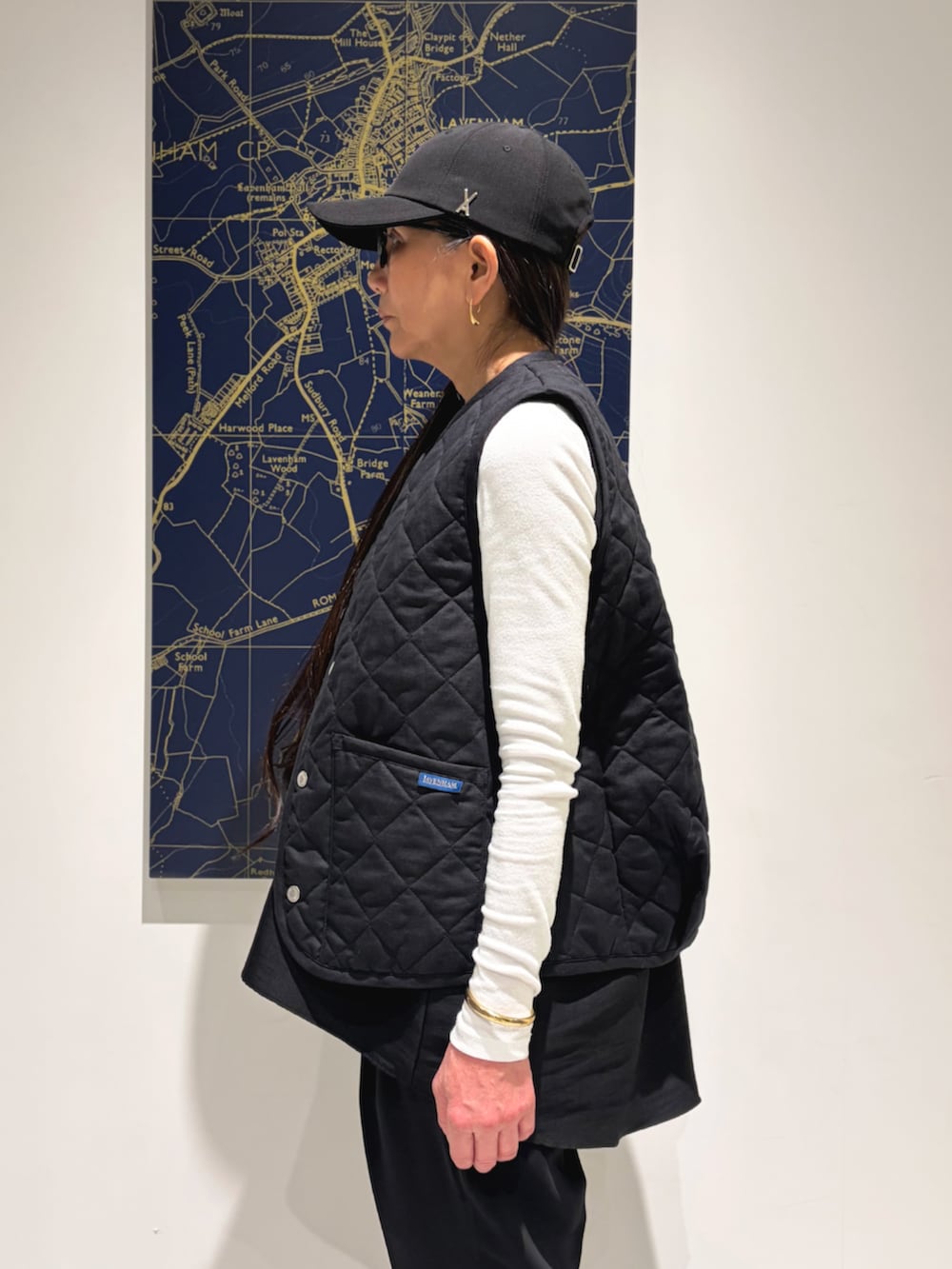 ブラック系のベストを着用したレディースの春コーディネートの3枚目の写真