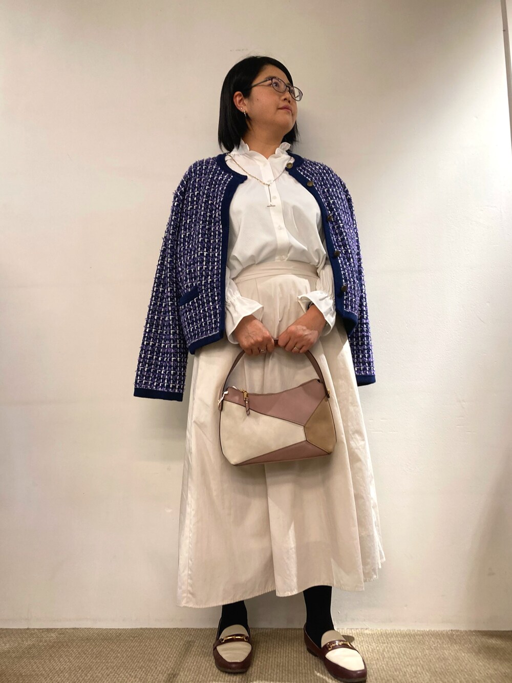 ピンク系のハンドバッグ、ホワイト系のビジネスシャツ、ブルー系のジャケット/アウターを着用したレディースの冬コーディネートの2枚目の写真