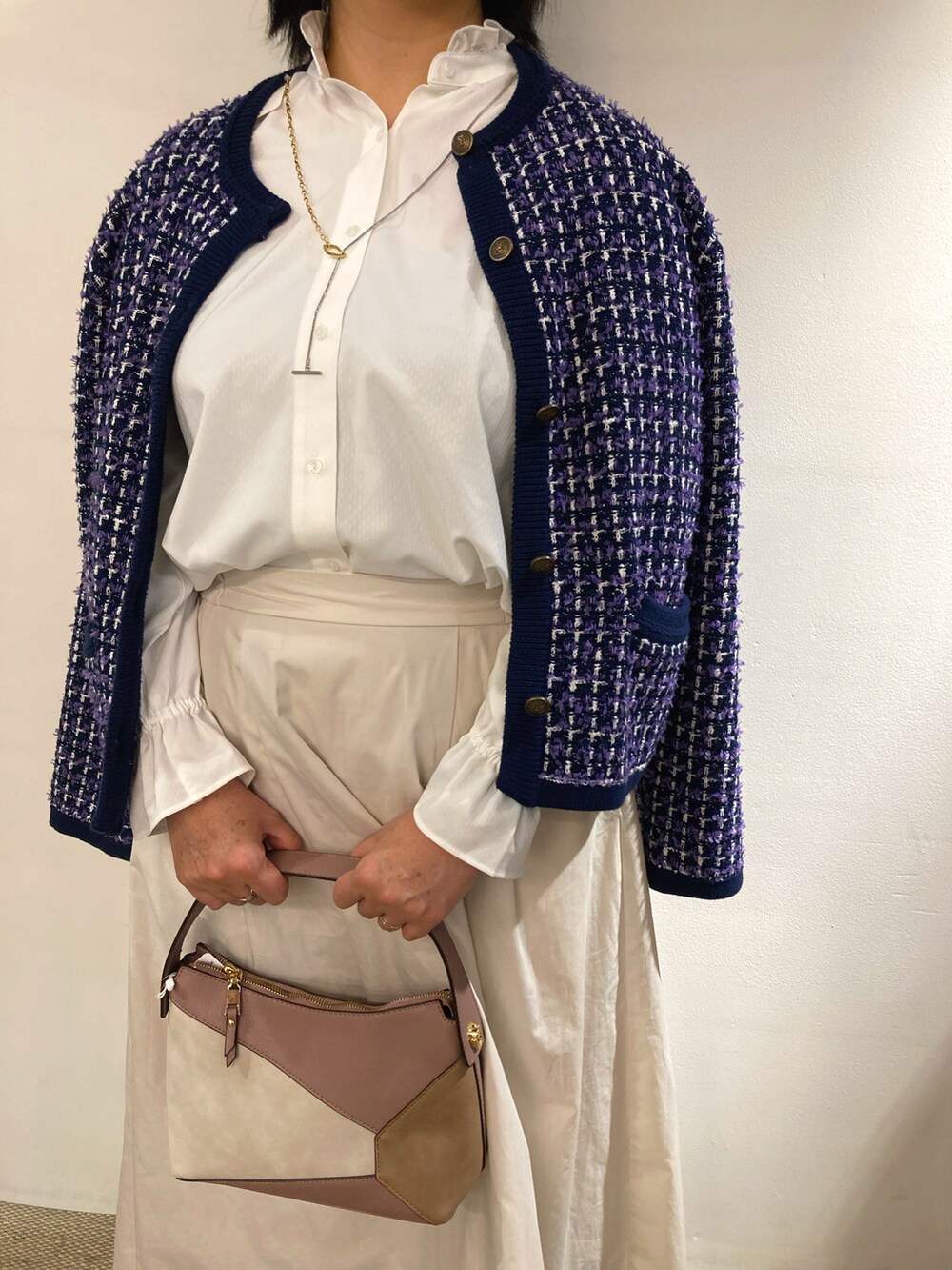 ピンク系のハンドバッグ、ホワイト系のビジネスシャツ、ブルー系のジャケット/アウターを着用したレディースの冬コーディネートの3枚目の写真