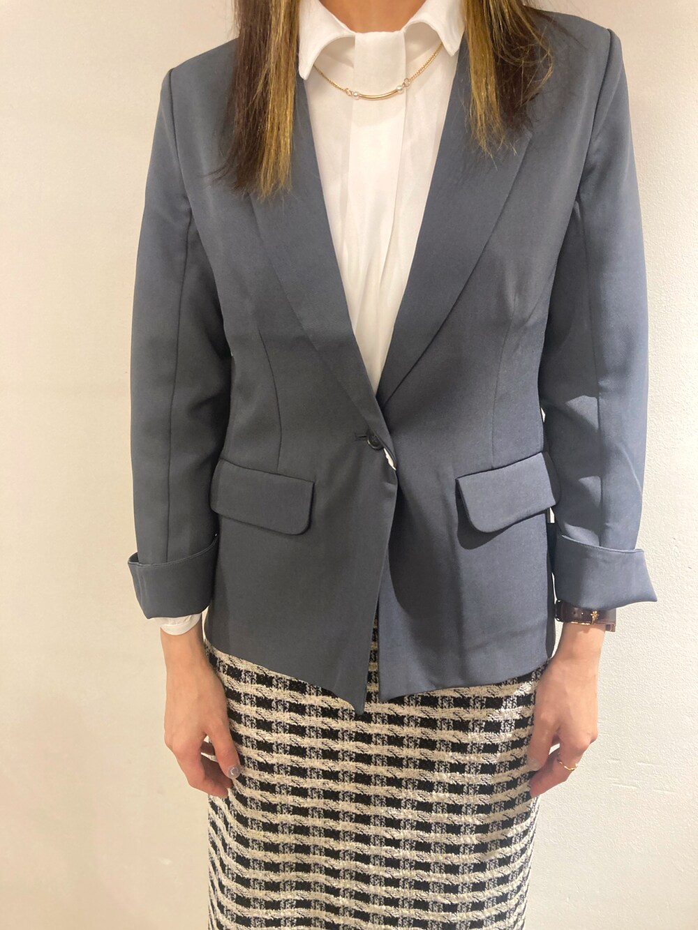 グレー系のテーラードジャケット、ホワイト系のシャツ/ブラウスを着用したレディースの冬コーディネートの2枚目の写真