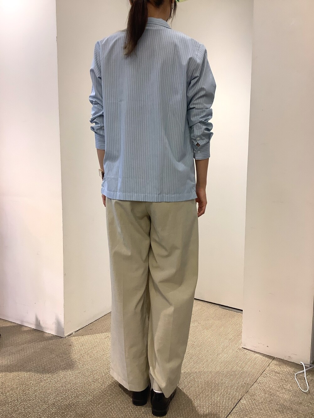 グリーン系のビジネスシャツ、ベージュ系のその他パンツ、ブラック系のレインシューズを着用したレディースの秋コーディネートの2枚目の写真