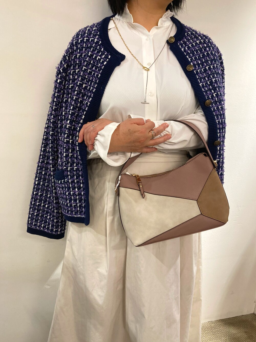 ピンク系のハンドバッグ、ホワイト系のビジネスシャツ、ブルー系のジャケット/アウターを着用したレディースの冬コーディネートの4枚目の写真