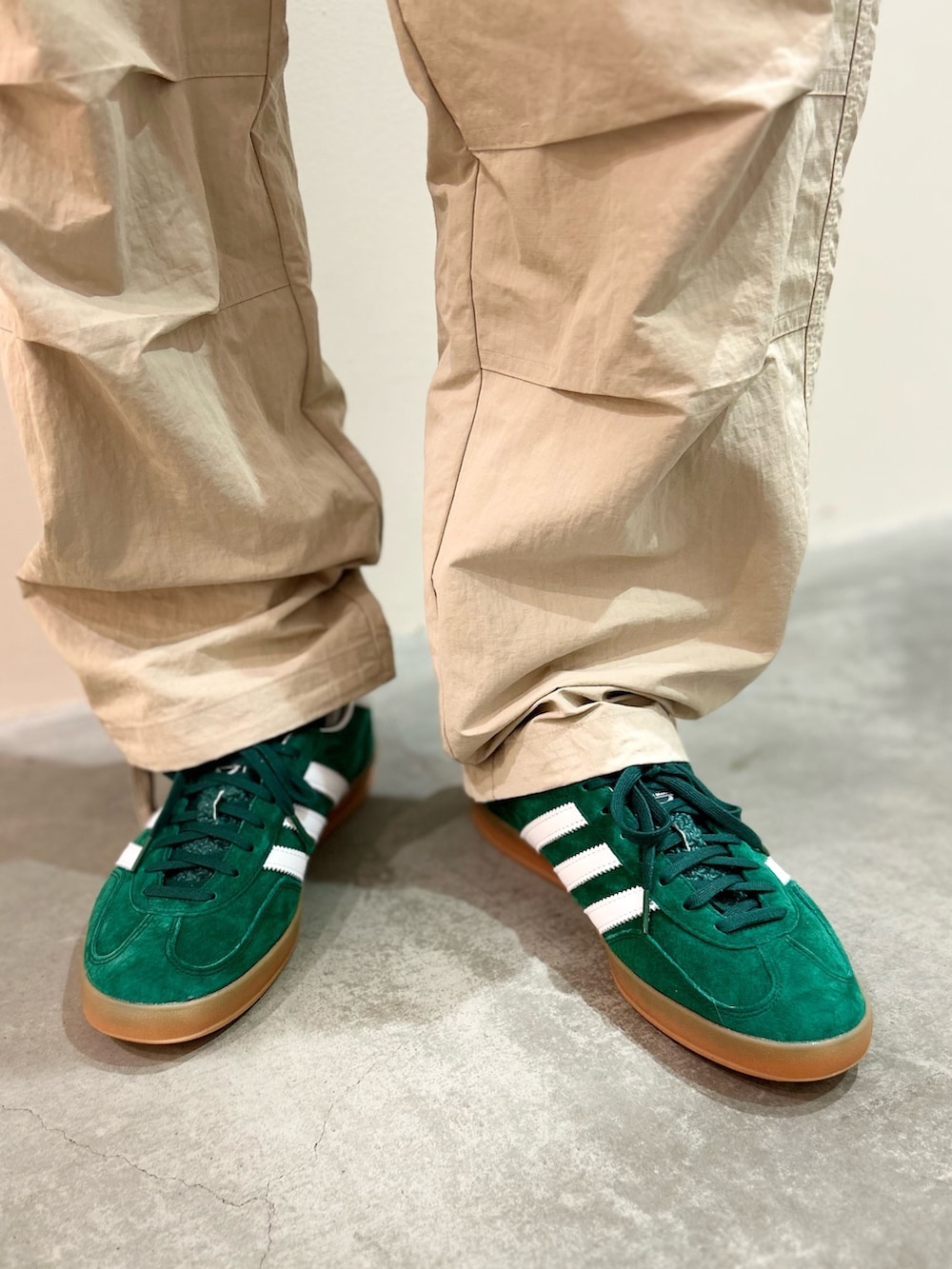 ベージュ系のカーゴパンツ、ブラック系のジャージ、グリーン系のスニーカーを着用したメンズの夏コーディネートの4枚目の写真