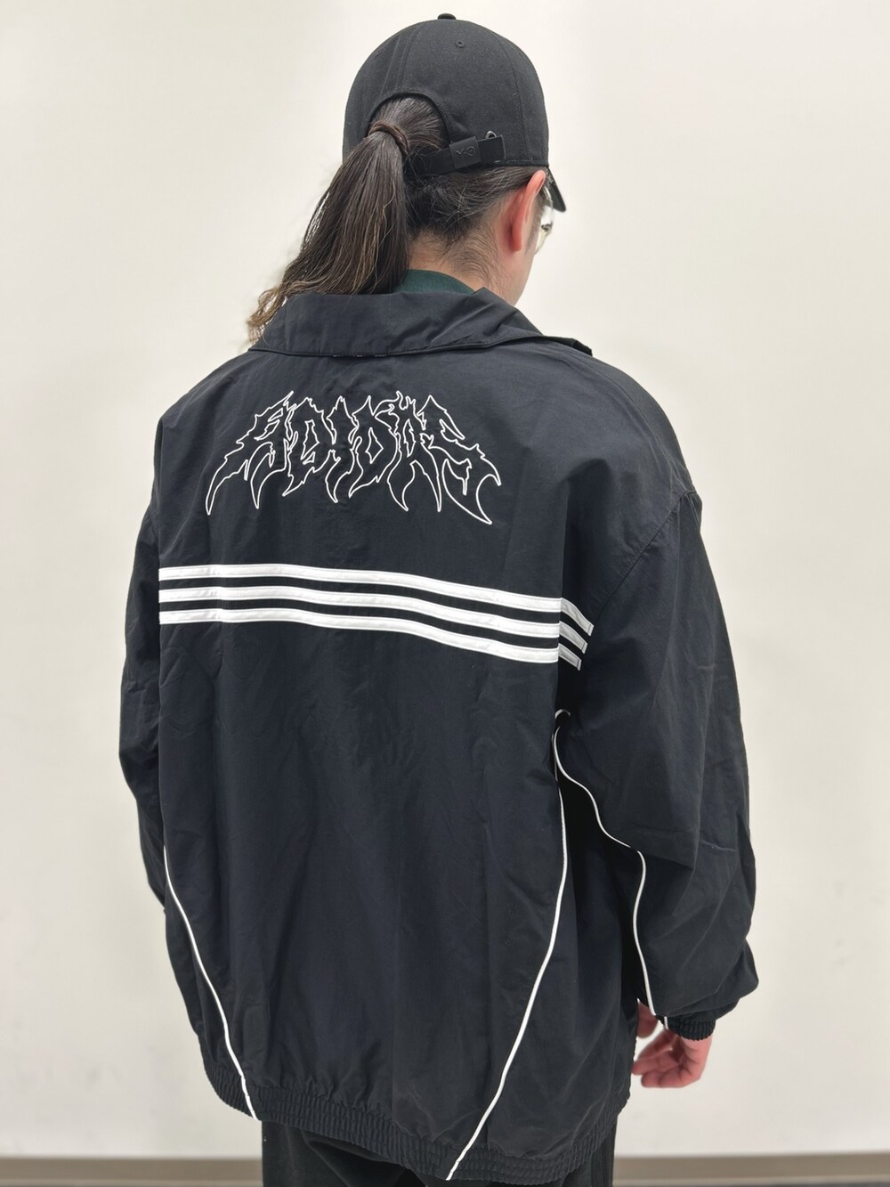 ブラック系のブルゾン、レッド系のスニーカーを着用したメンズの春コーディネートの2枚目の写真