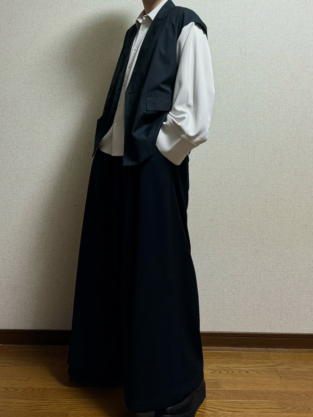 ブラック系のドレスシューズ、ブラック系のスラックス、ホワイト系のシャツ/ブラウスを着用したメンズの春コーディネートの3枚目の写真