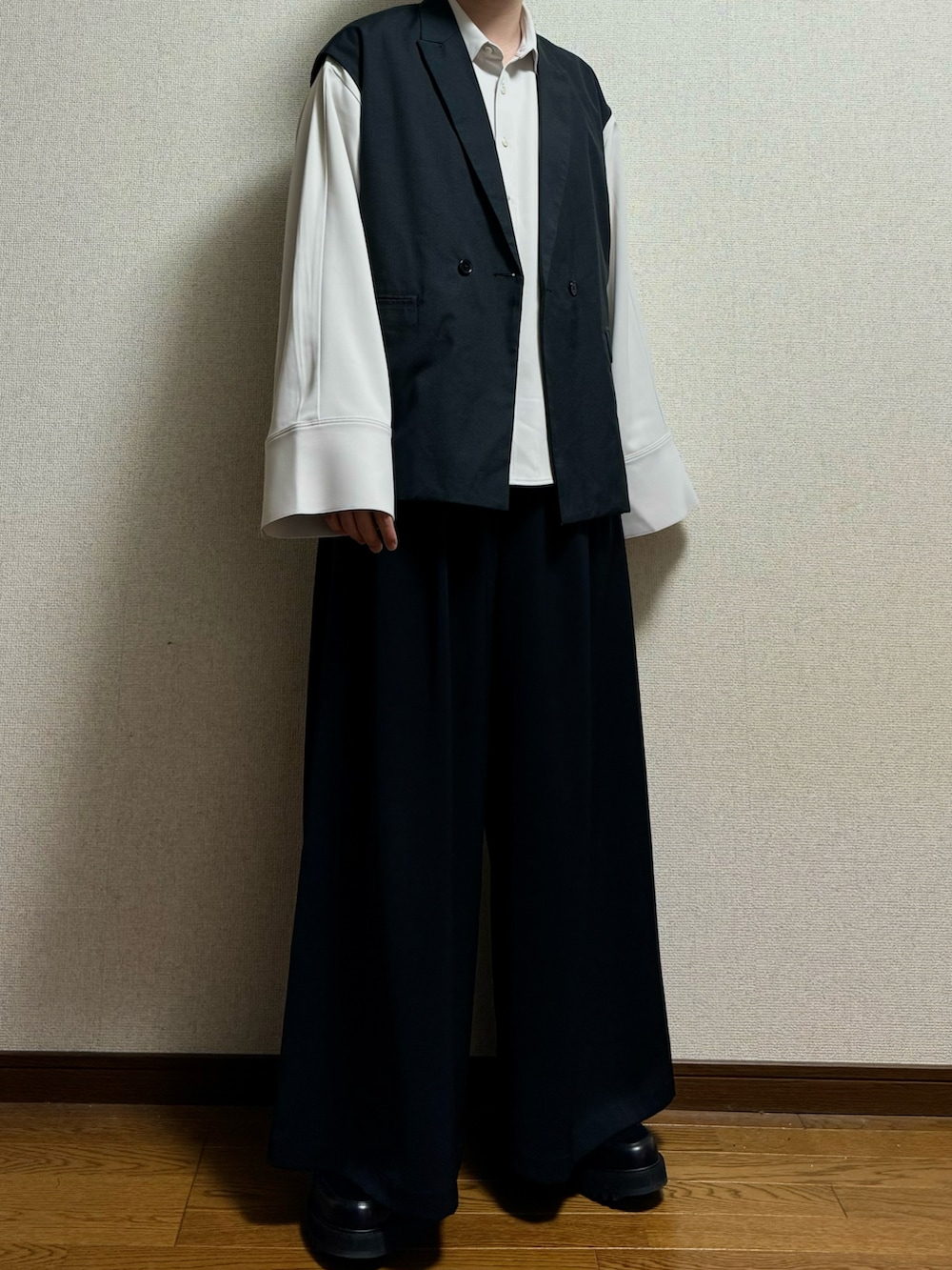 ブラック系のドレスシューズ、ブラック系のスラックス、ホワイト系のシャツ/ブラウスを着用したメンズの春コーディネートの2枚目の写真