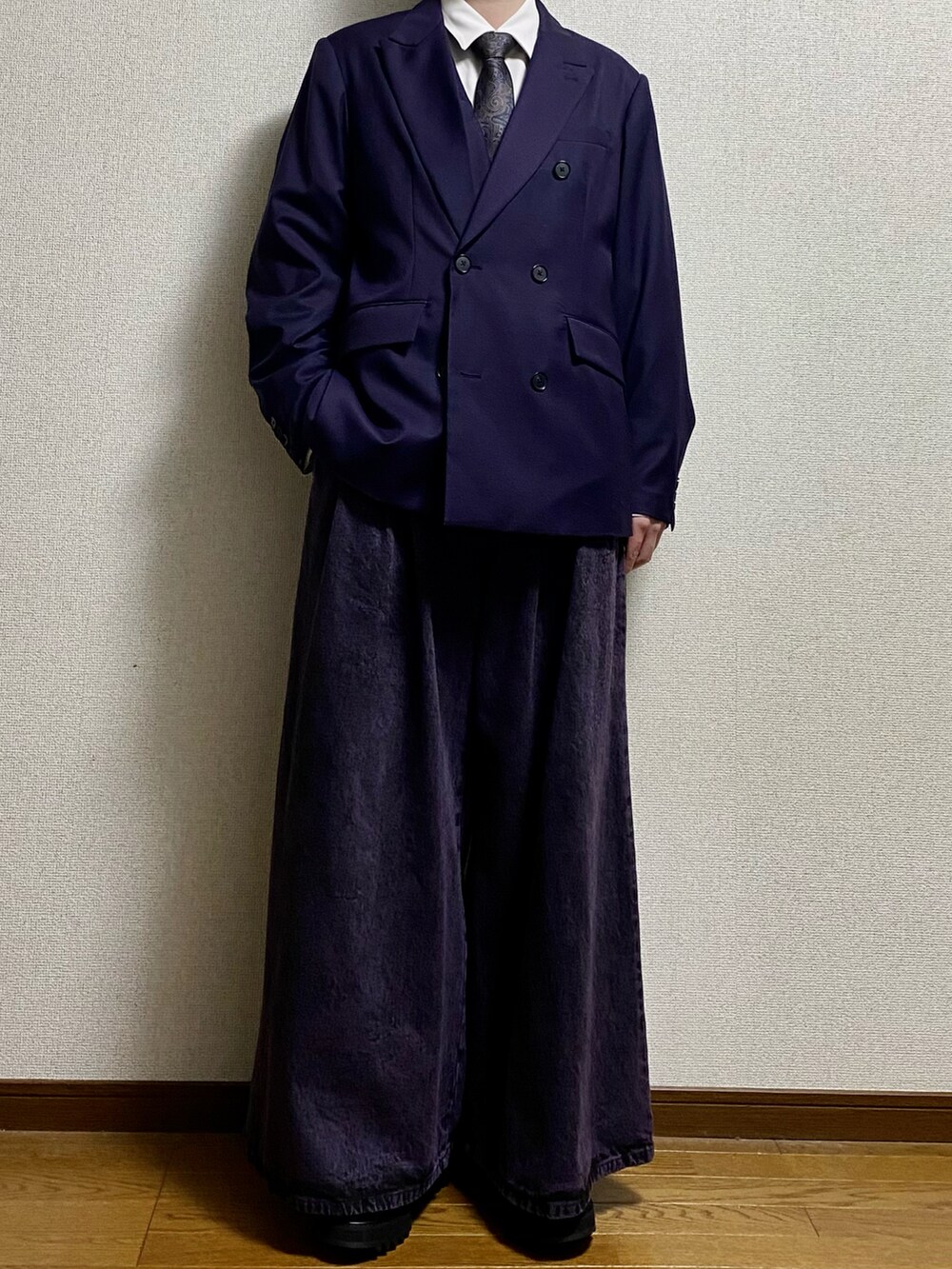 ブラック系のスラックス、ブラック系のドレスシューズ、パープル系のテーラードジャケットを着用したメンズの春コーディネートの5枚目の写真