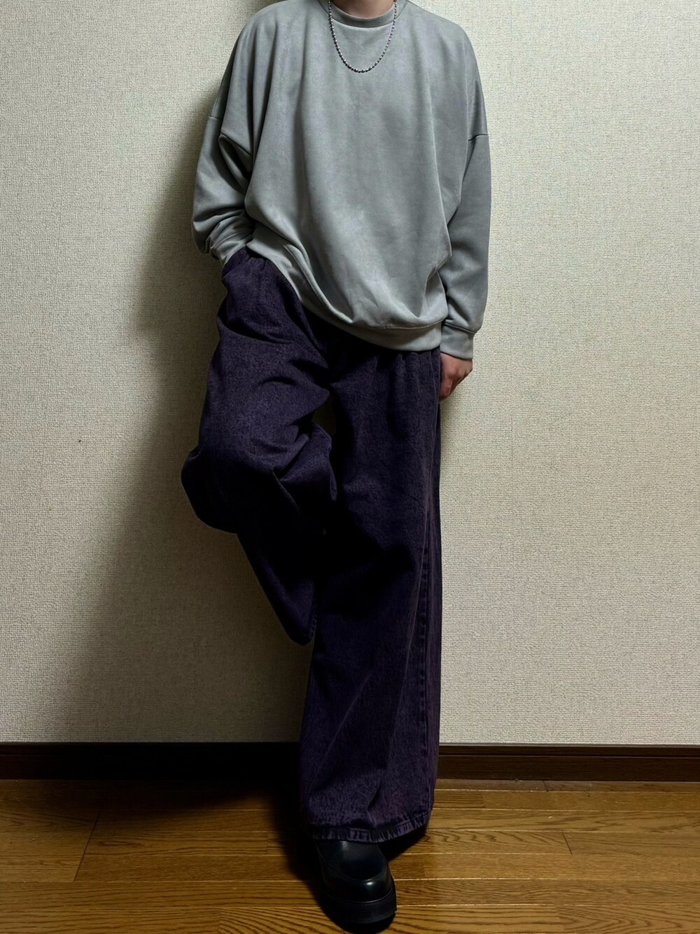 パープル系のデニムパンツ、グレー系のスウェット、ブラック系のドレスシューズを着用したメンズの春コーディネートの2枚目の写真