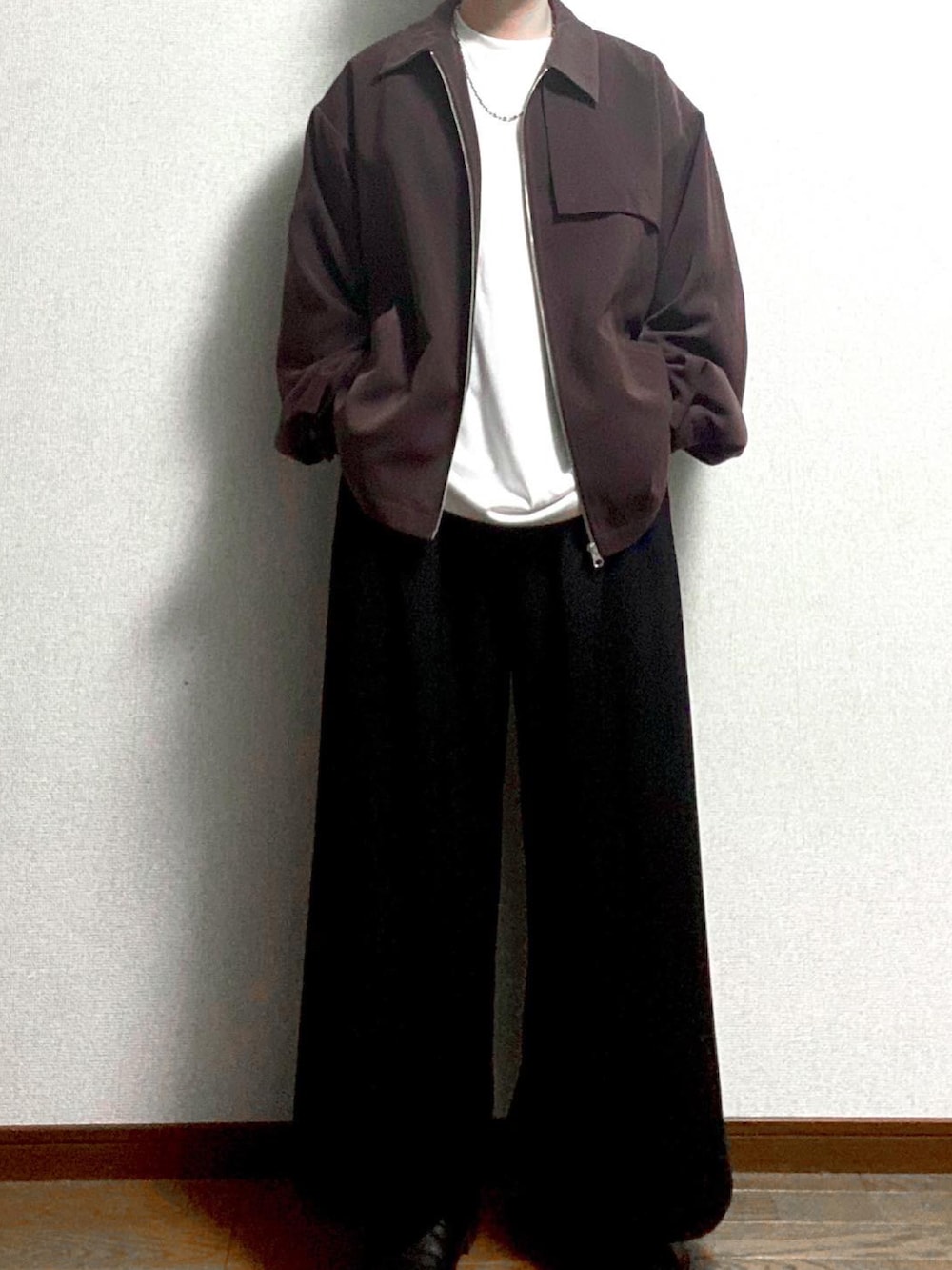 ブラウン系のブルゾン、ホワイト系のTシャツ/カットソー、ブラック系のスラックスを着用したメンズの冬コーディネートの3枚目の写真