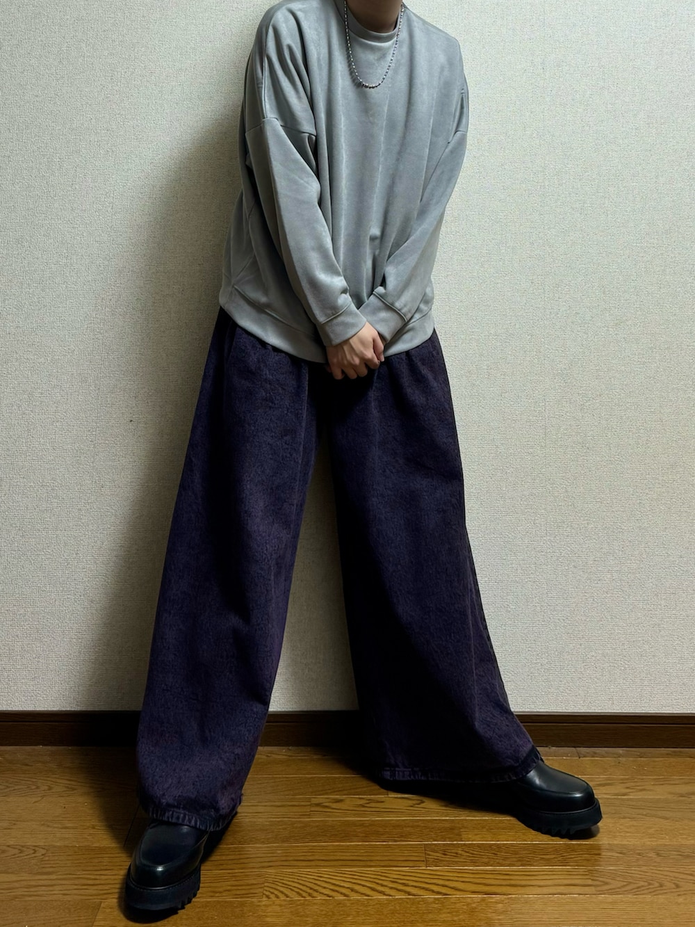 パープル系のデニムパンツ、グレー系のスウェット、ブラック系のドレスシューズを着用したメンズの春コーディネートの3枚目の写真