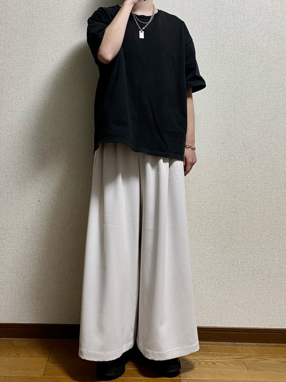 ブラック系のTシャツ/カットソー、ホワイト系のスラックス、ブラック系のドレスシューズを着用したメンズの春コーディネートの4枚目の写真