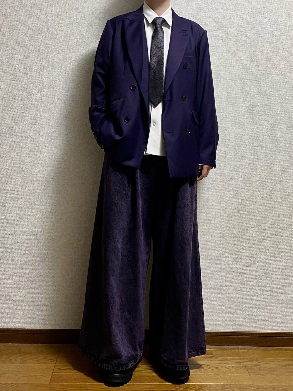 ブラック系のスラックス、ブラック系のドレスシューズ、パープル系のテーラードジャケットを着用したメンズの春コーディネートの4枚目の写真