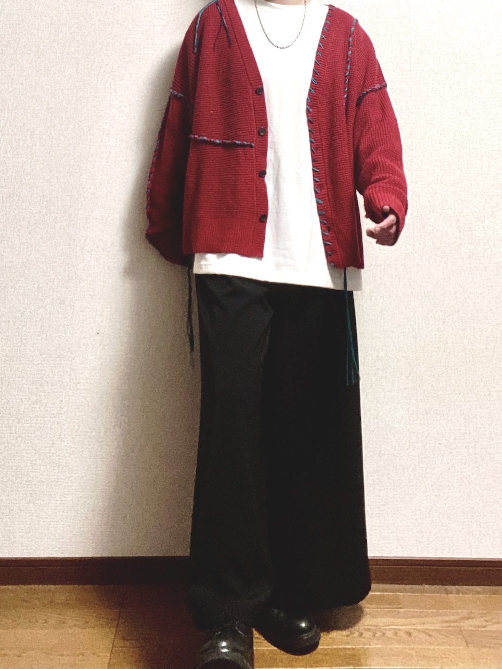 オレンジ系のカーディガン/ボレロ、ホワイト系のTシャツ/カットソー、ブラック系のスラックスを着用したメンズの冬コーディネートの2枚目の写真