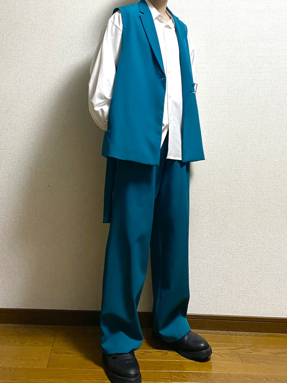 グリーン系のスラックス、グリーン系のベスト、ホワイト系のシャツ/ブラウスを着用したメンズの春コーディネートの2枚目の写真