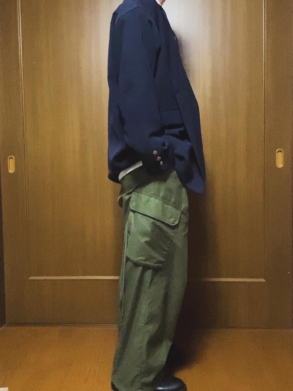 ベージュ系のトートバッグ、ブルー系のテーラードジャケット、ブルー系のネクタイを着用したメンズの冬コーディネートの3枚目の写真