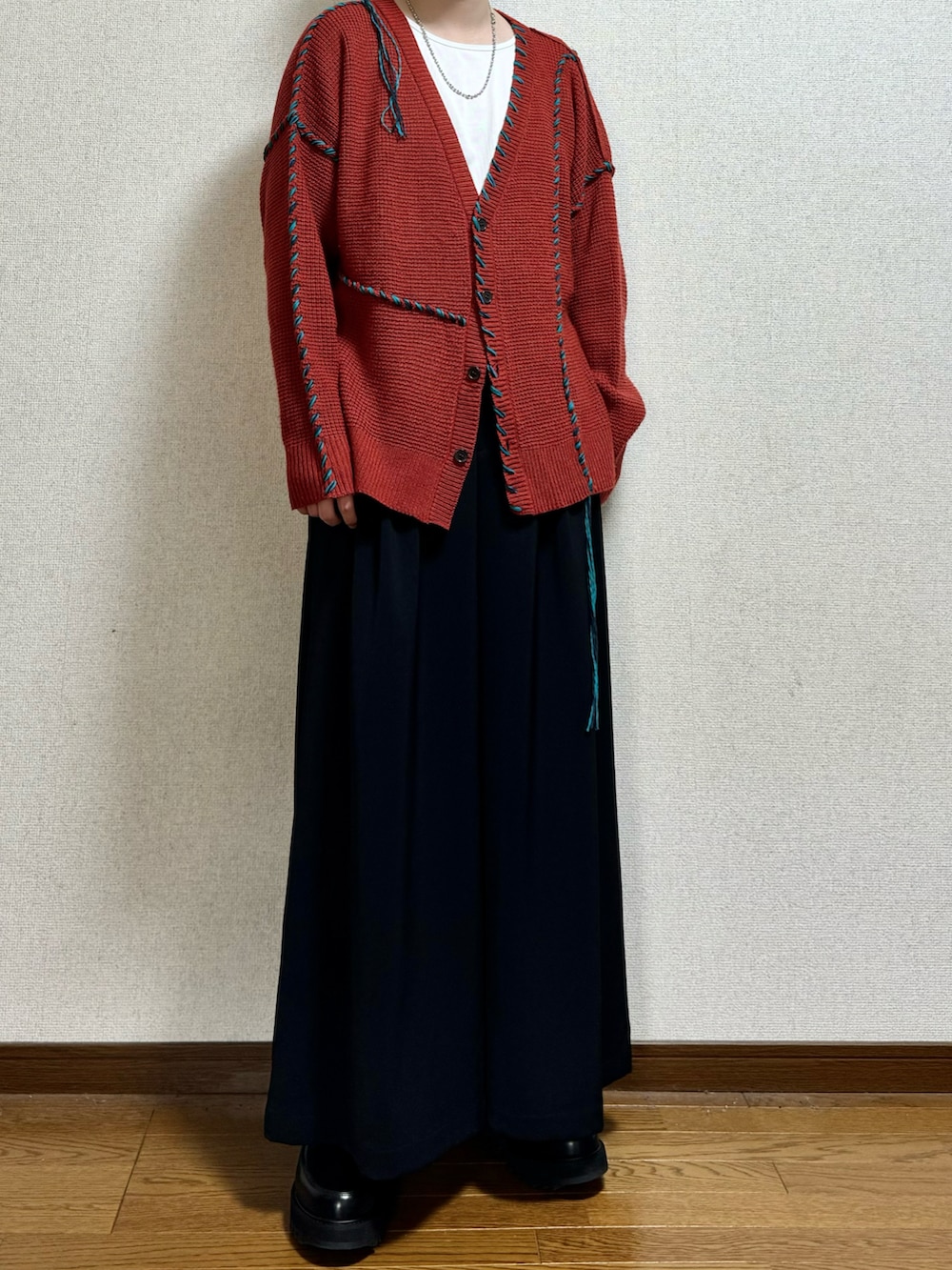 オレンジ系のカーディガン/ボレロ、ホワイト系のTシャツ/カットソー、ブラック系のスラックスを着用したメンズの春コーディネートの2枚目の写真