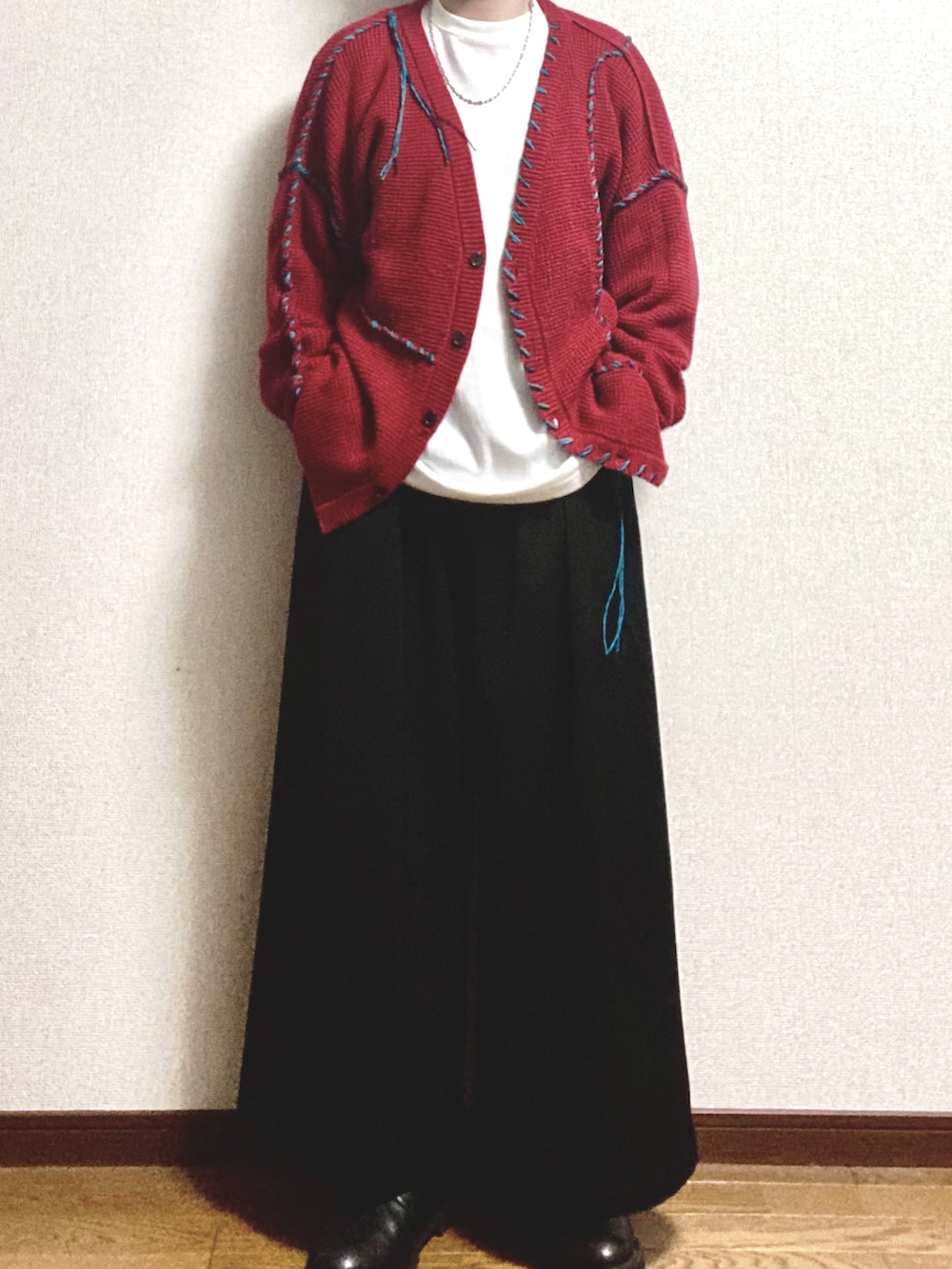 オレンジ系のカーディガン/ボレロ、ホワイト系のTシャツ/カットソー、ブラック系のスラックスを着用したメンズの冬コーディネートの3枚目の写真