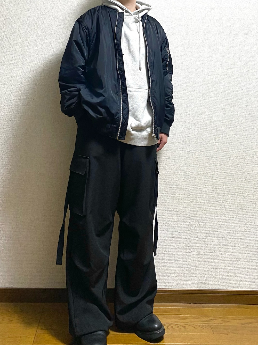 ブラック系のカーゴパンツ、グレー系のパーカー、ブラック系のMA-1を着用したメンズの春コーディネートの3枚目の写真