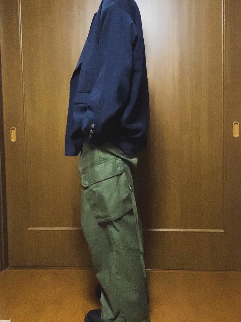 ベージュ系のトートバッグ、ブルー系のテーラードジャケット、ブルー系のネクタイを着用したメンズの冬コーディネートの5枚目の写真