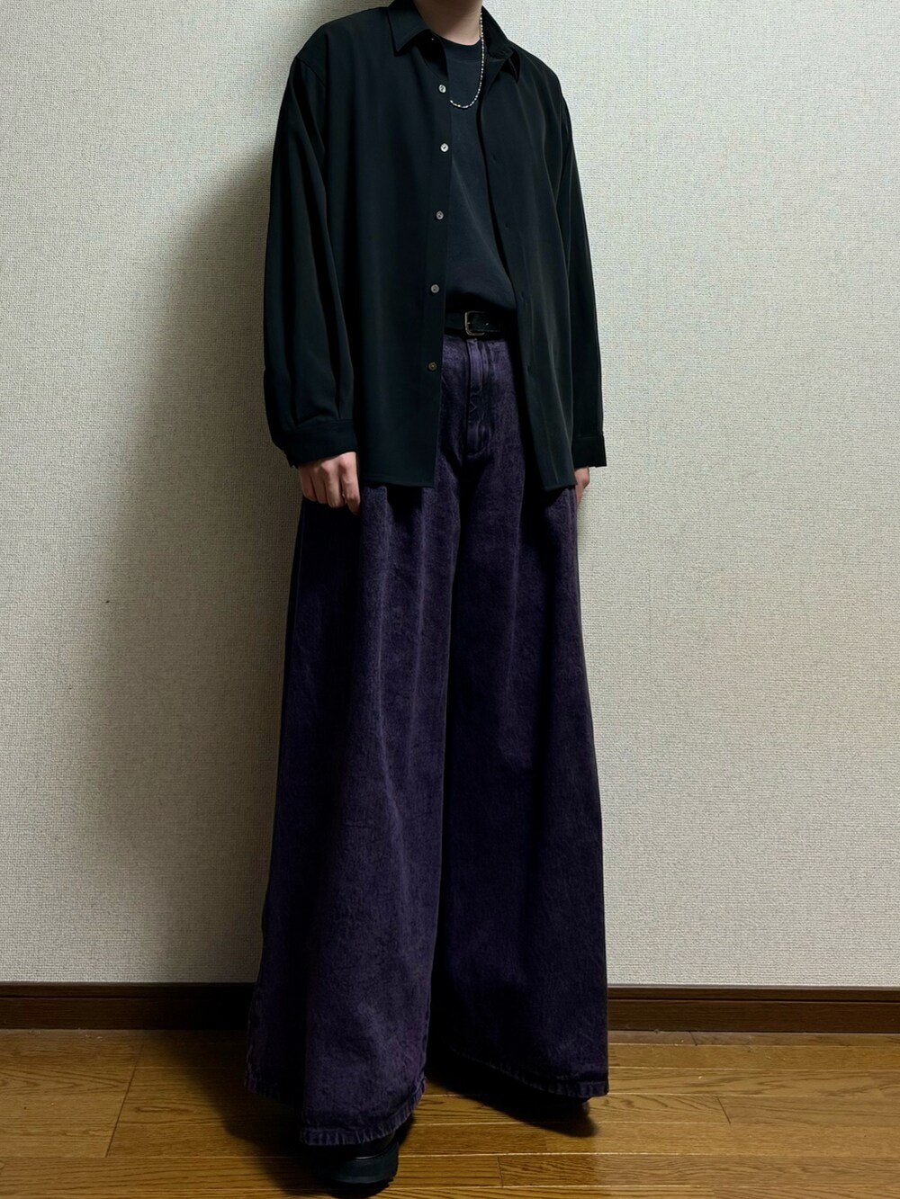 パープル系のデニムパンツ、ブラック系のドレスシューズ、ブラック系のシャツ/ブラウスを着用したメンズの春コーディネートの3枚目の写真