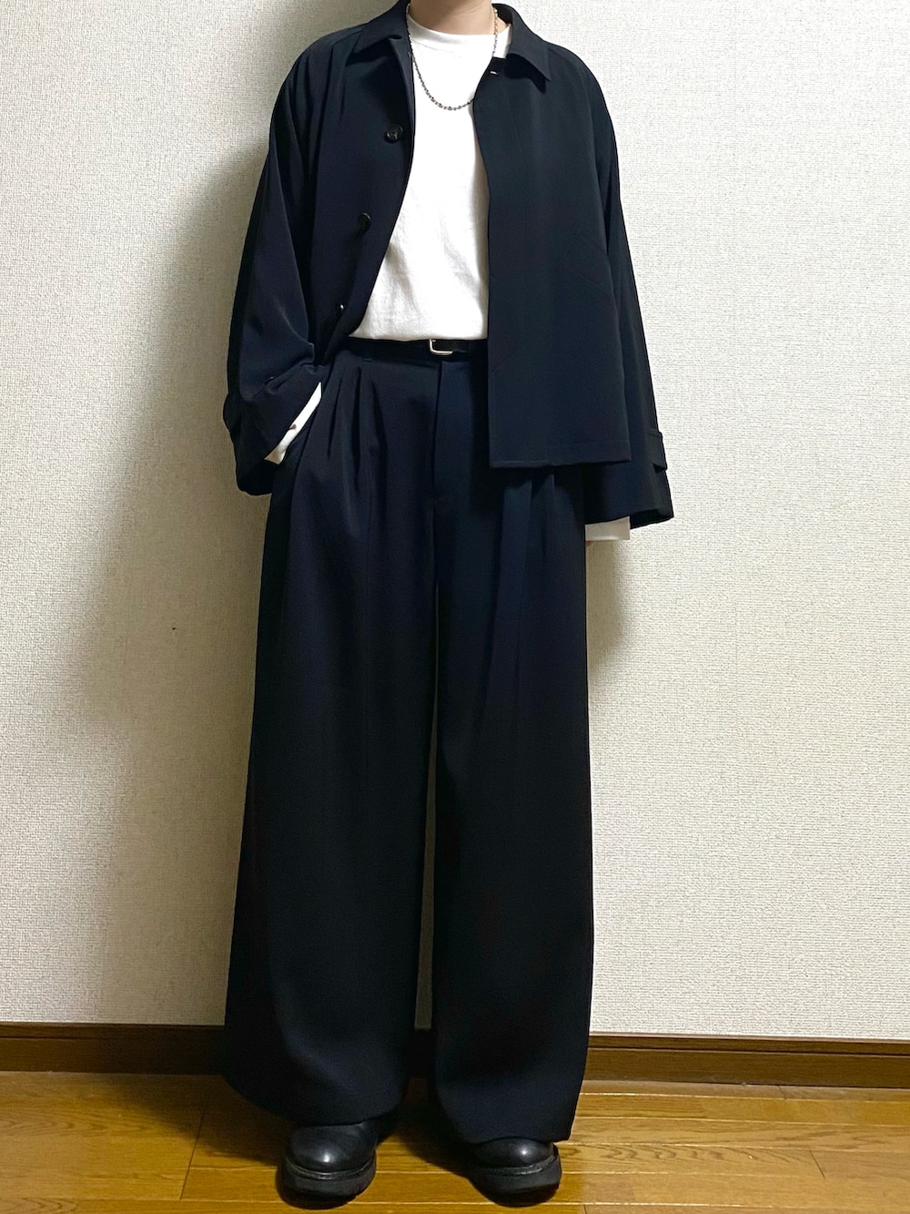 ブラック系のブルゾン、ブラック系のスラックス、ホワイト系のTシャツ/カットソーを着用したメンズの春コーディネートの2枚目の写真