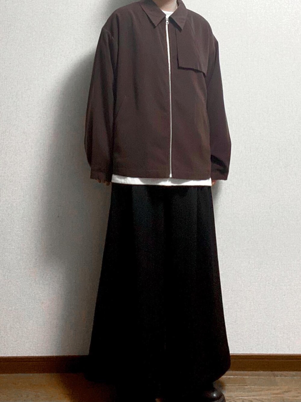 ブラウン系のブルゾン、ホワイト系のTシャツ/カットソー、ブラック系のスラックスを着用したメンズの冬コーディネートの2枚目の写真