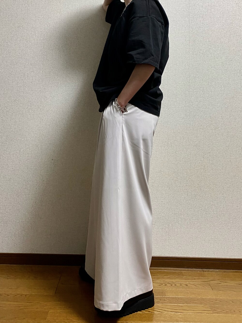 ブラック系のTシャツ/カットソー、ホワイト系のスラックス、ブラック系のドレスシューズを着用したメンズの春コーディネートの2枚目の写真