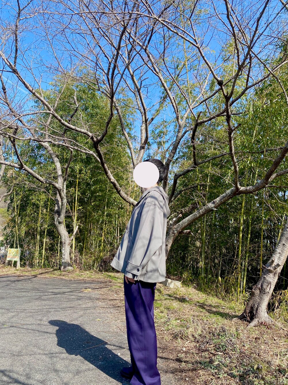 パープル系のスラックス、グレー系のマウンテンパーカー、グレー系のスウェットを着用したメンズの冬コーディネートの3枚目の写真