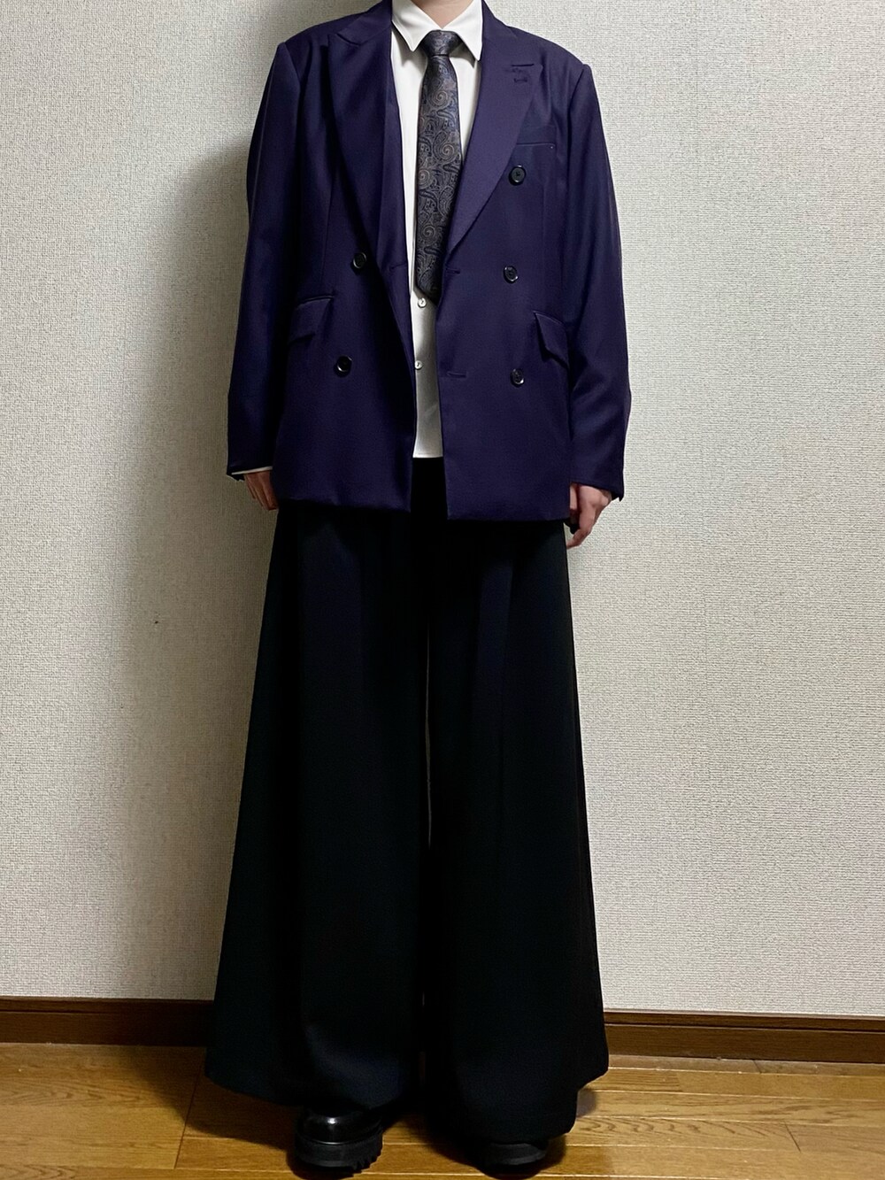 ブラック系のスラックス、ブラック系のドレスシューズ、パープル系のテーラードジャケットを着用したメンズの春コーディネートの2枚目の写真