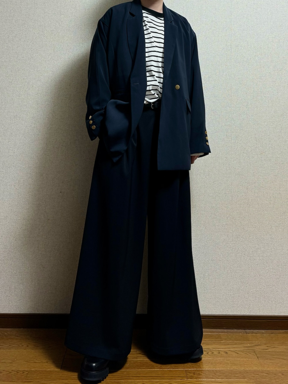 ブラック系のスラックス、ブラック系のドレスシューズ、ブルー系のテーラードジャケットを着用したメンズの春コーディネートの2枚目の写真