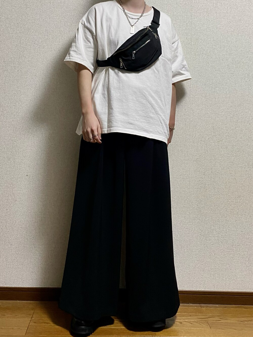 ホワイト系のTシャツ/カットソー、ブラック系のボディバッグ/ウエストポーチ、ブラック系のスラックスを着用したメンズの春コーディネートの2枚目の写真