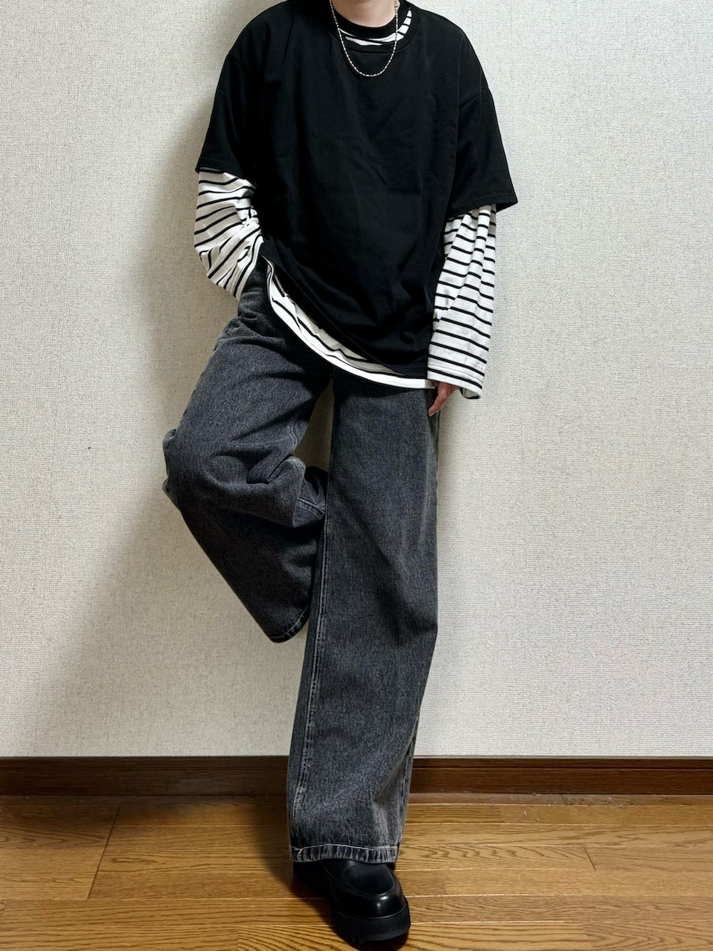 ブラック系のドレスシューズ、ブラック系のデニムパンツ、ホワイト系のTシャツ/カットソーを着用したメンズの春コーディネートの2枚目の写真