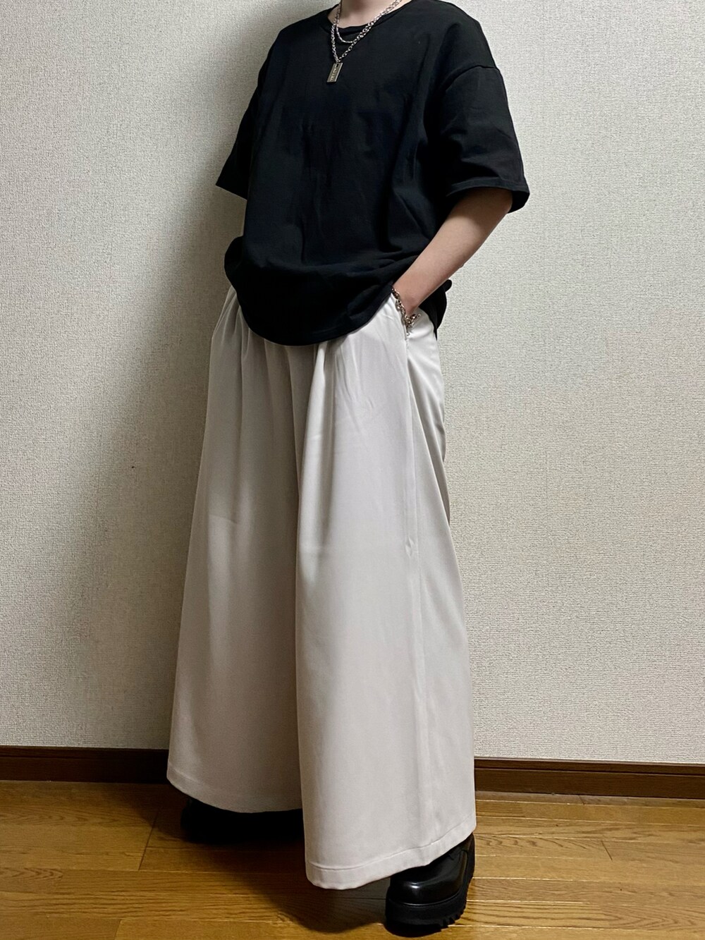 ブラック系のTシャツ/カットソー、ホワイト系のスラックス、ブラック系のドレスシューズを着用したメンズの春コーディネートの3枚目の写真