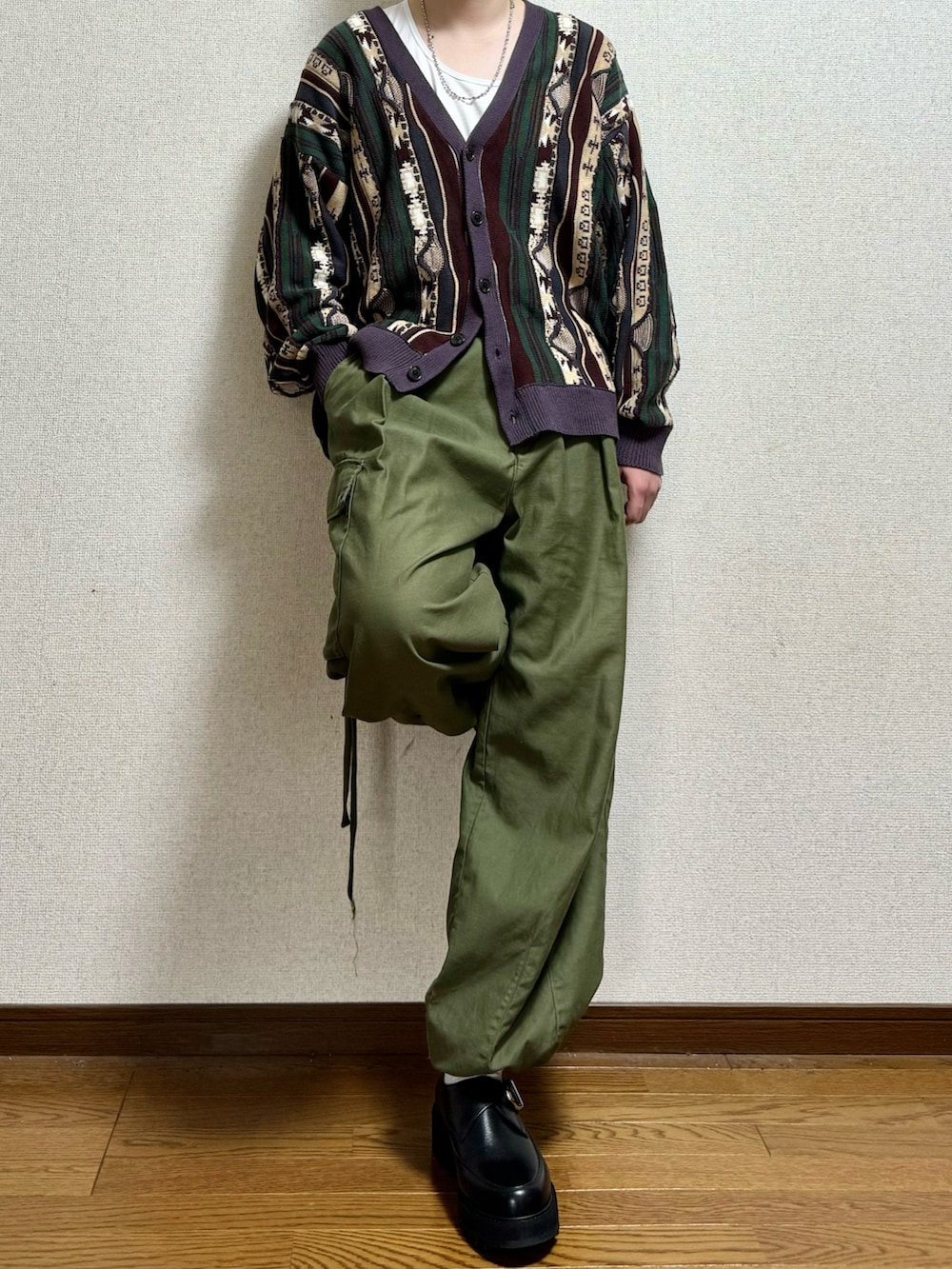 ブラック系のドレスシューズ、グリーン系のカーゴパンツ、グリーン系のカーディガン/ボレロを着用したメンズの春コーディネートの2枚目の写真