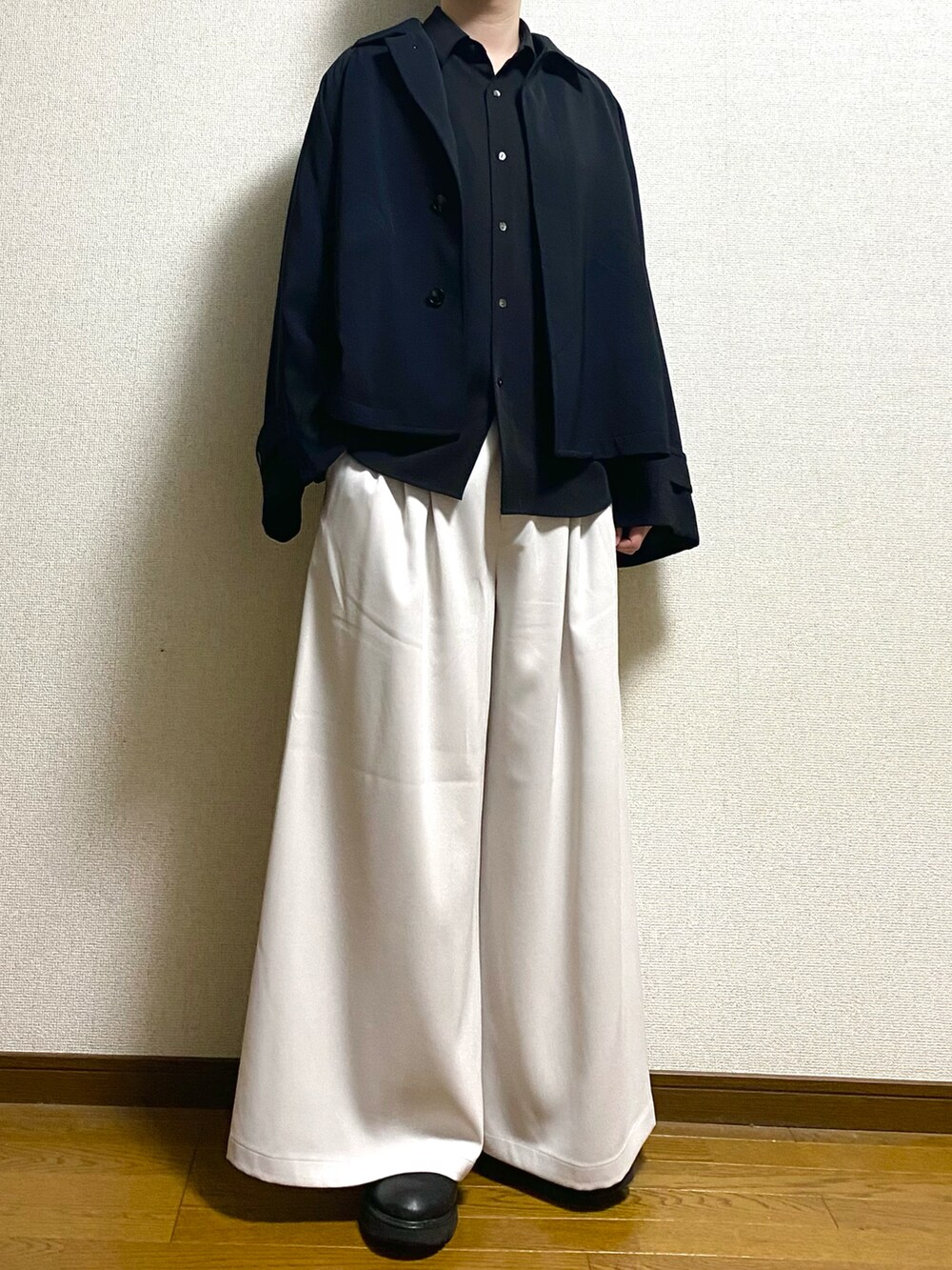 ブラック系のシャツ/ブラウス、ホワイト系のスラックス、ブラック系のブルゾンを着用したメンズの春コーディネートの2枚目の写真