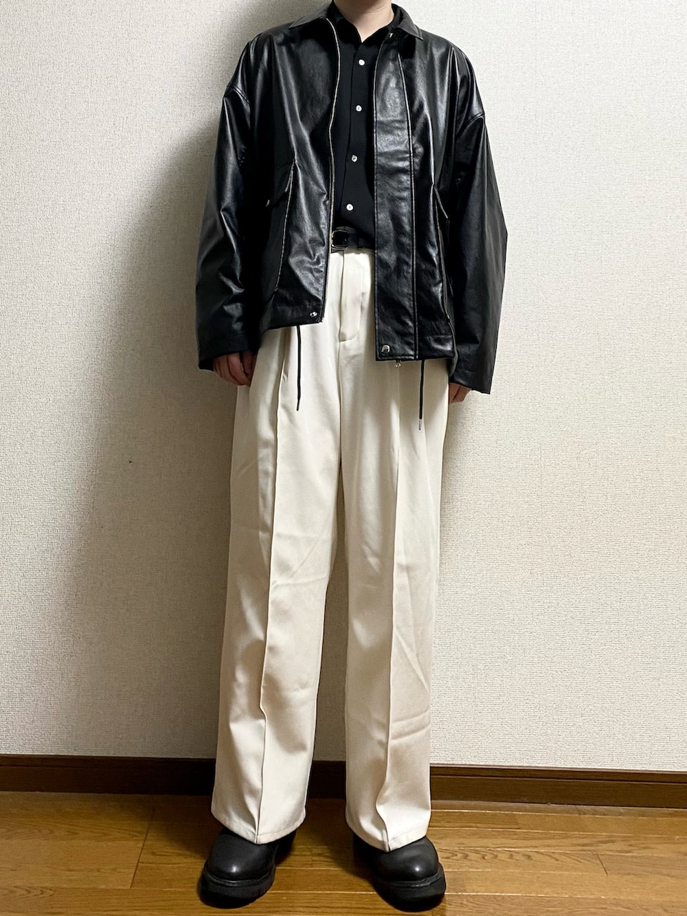 ホワイト系のスラックス、ブラック系のブルゾン、ブラック系のシャツ/ブラウスを着用したメンズの春コーディネートの2枚目の写真
