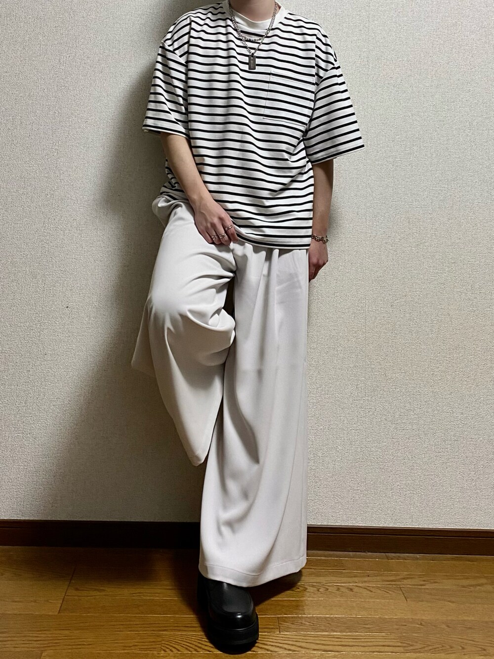 ホワイト系のTシャツ/カットソー、ホワイト系のスラックス、ブラック系のドレスシューズを着用したメンズの春コーディネートの2枚目の写真