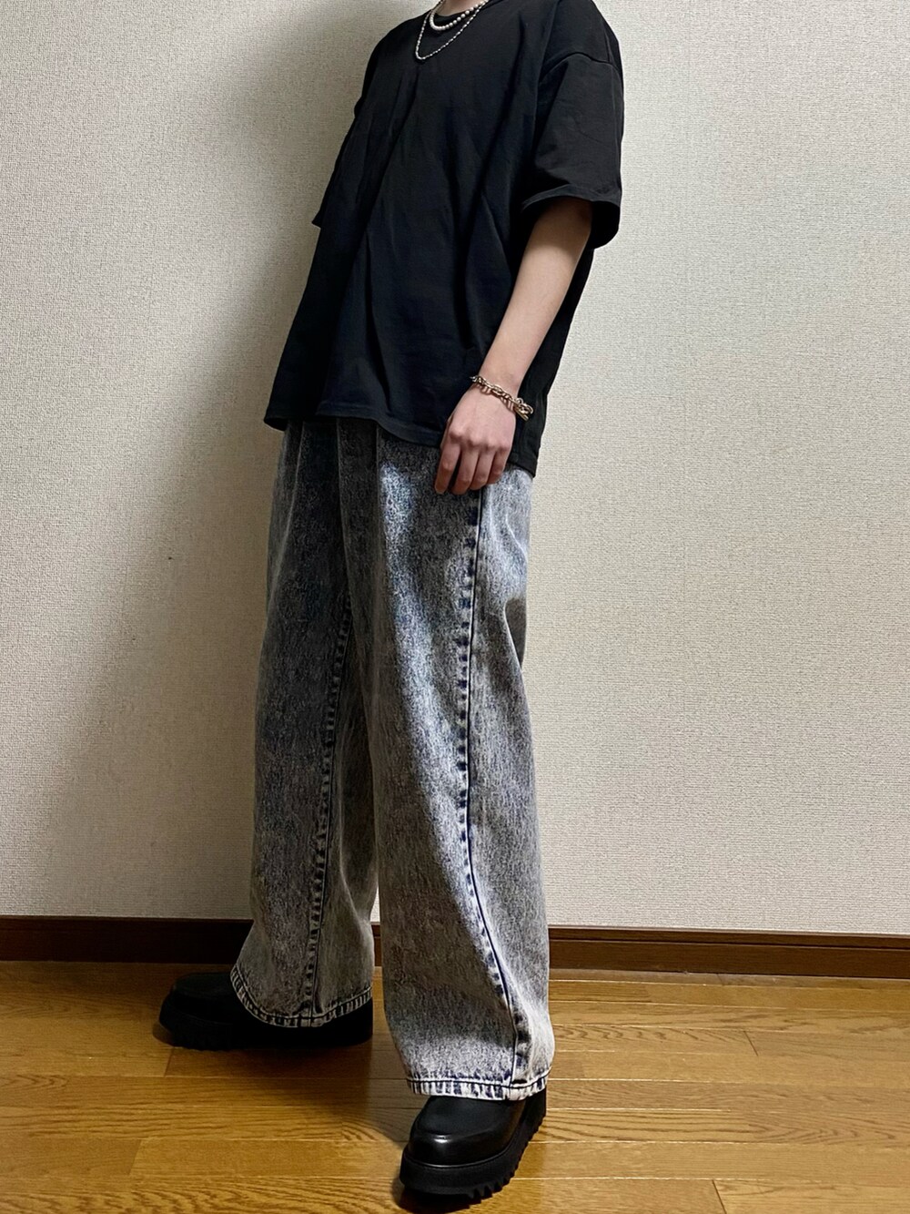 ブルー系のデニムパンツ、ブラック系のドレスシューズ、ブラック系のTシャツ/カットソーを着用したメンズの春コーディネートの2枚目の写真