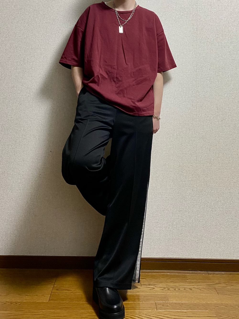 ブラック系のその他パンツ、ブラック系のドレスシューズ、レッド系のTシャツ/カットソーを着用したメンズの春コーディネートの2枚目の写真