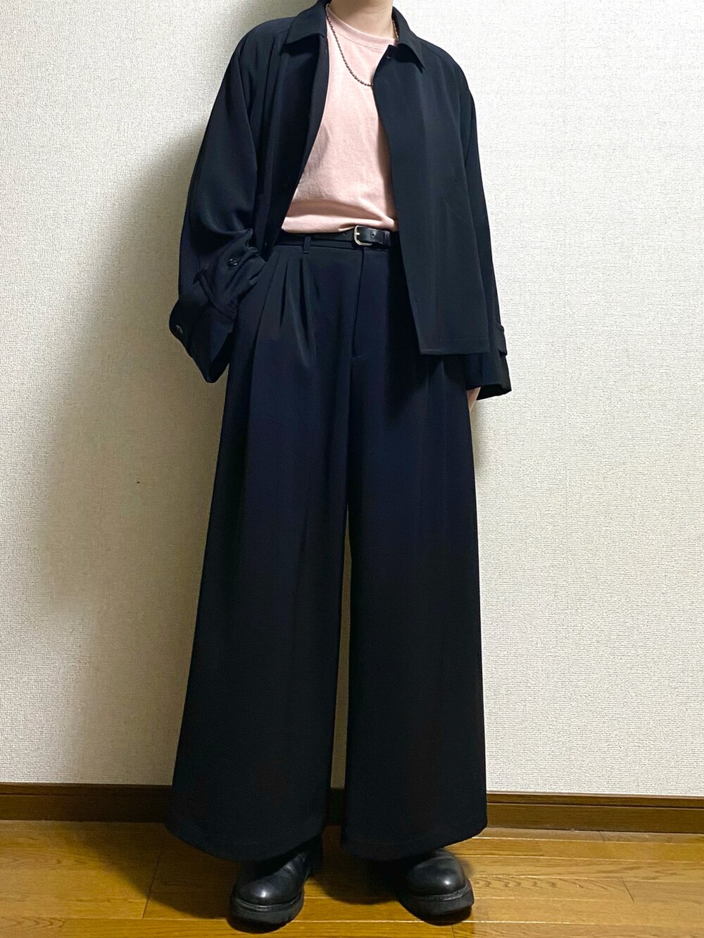 ブラック系のブルゾン、ブラック系のスラックス、ホワイト系のTシャツ/カットソーを着用したメンズの春コーディネートの3枚目の写真