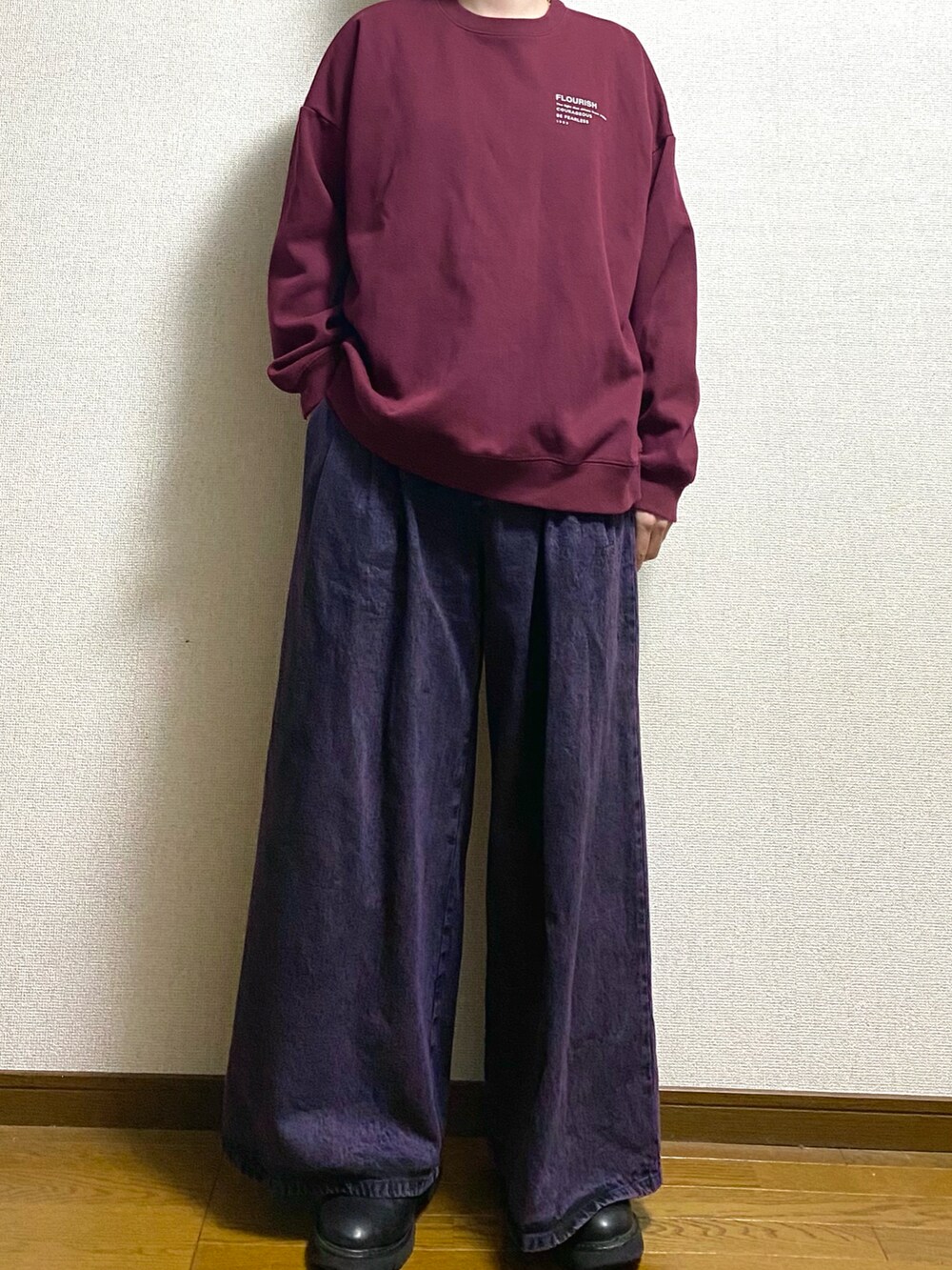 パープル系のデニムパンツ、レッド系のスウェットを着用したメンズの春コーディネートの2枚目の写真